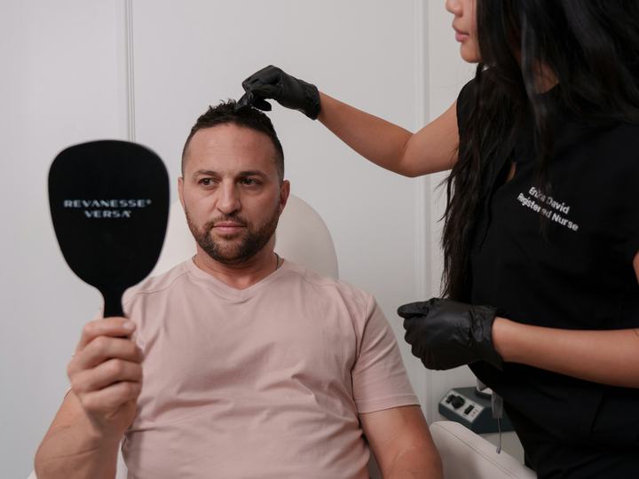 Specialist examining a man's hairline at a hair clinic