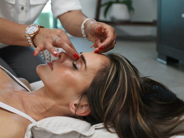Surgeon assessing a patient's nose before rhinoplasty
